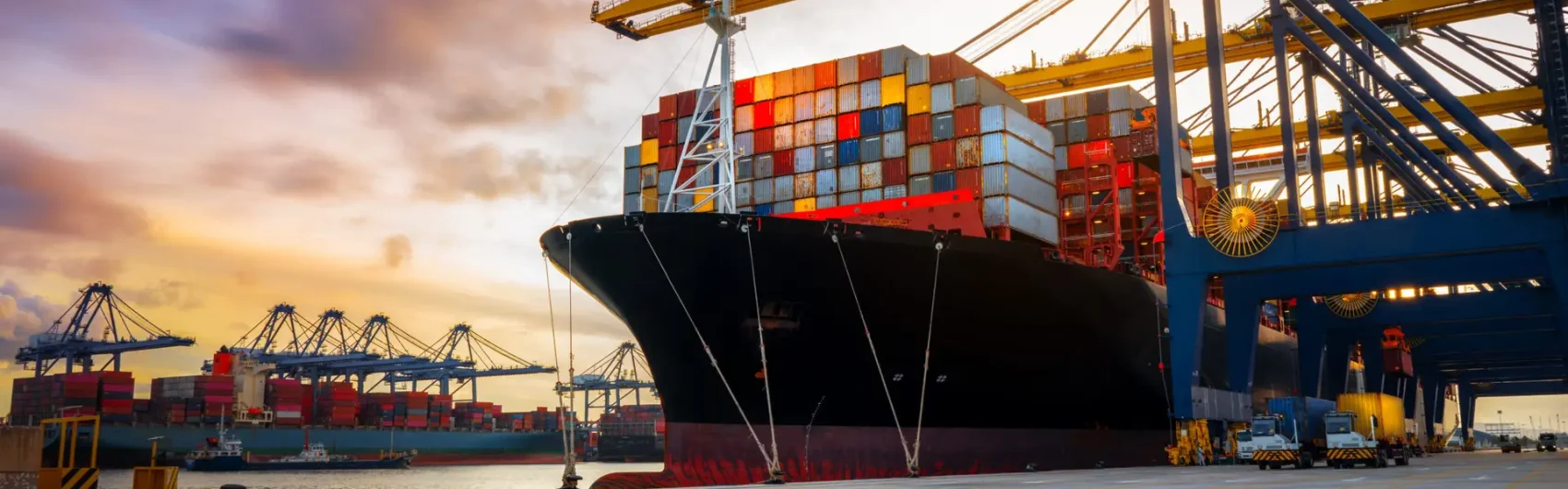 Crane loading Cargo Container export container ship in the international terminal logistics sea port concept freight shipping by ship, Truck running in port under the Big Crane transport trade